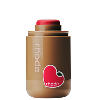 Rhode Skin Pocket Blush in Candy Apple with soft pink powder blush on a makeup palette, showcasing vibrant blush color and packaging.