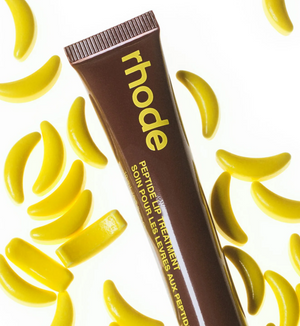 Rhode Skin caramelized banana lip treatment in a sleek makeup tube, showcasing a smooth, glossy finish on the lips.