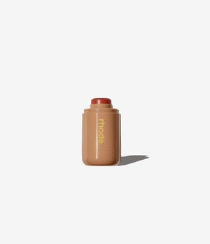 R. Beauty Sun Soaked blush in a warm, coral-pink shade with a smooth, matte finish, displayed in a sleek makeup compact.